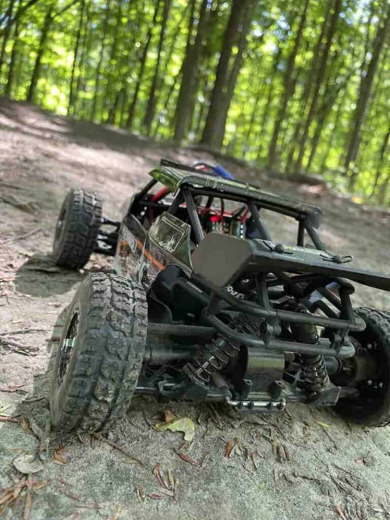 close up RC car trees and a trail in the background